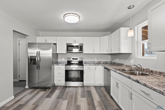 kitchen featuring decorative light fixtures, white cabinetry, and appliances with stainless steel finishes