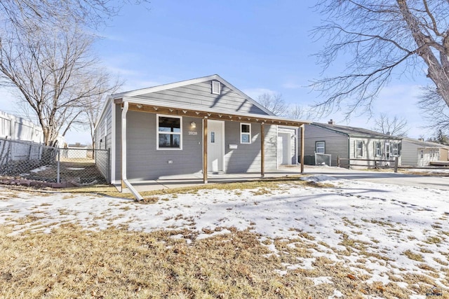 snow covered back of property with covered porch