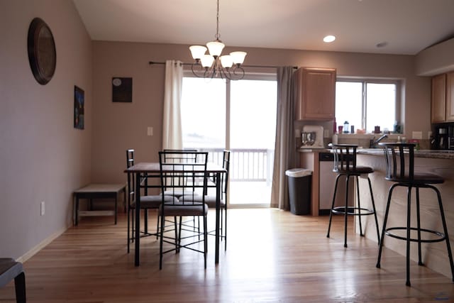 dining space featuring an inviting chandelier and light hardwood / wood-style flooring