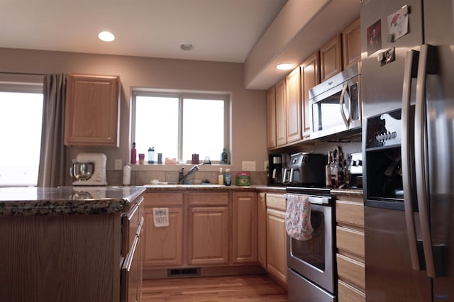 kitchen featuring light wood-type flooring, stainless steel appliances, light brown cabinets, and sink