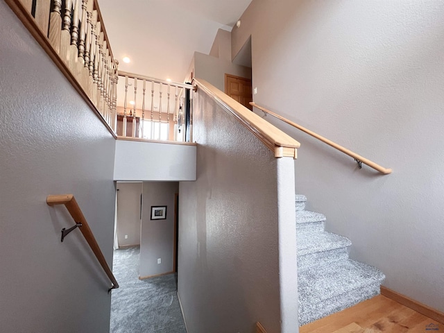 stairway featuring carpet flooring and a towering ceiling