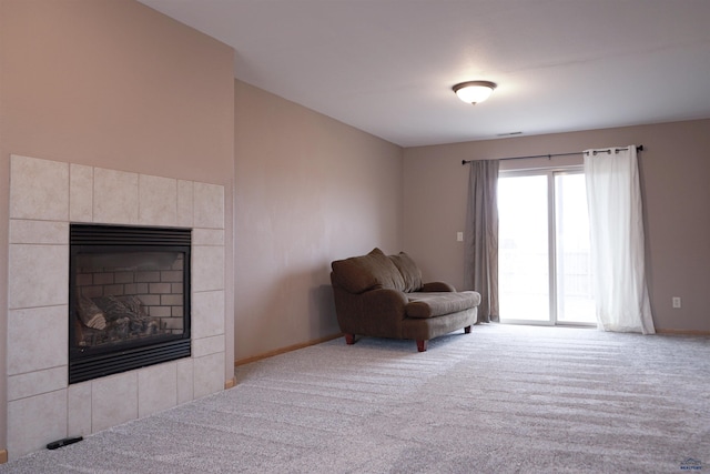 living area with light carpet and a fireplace