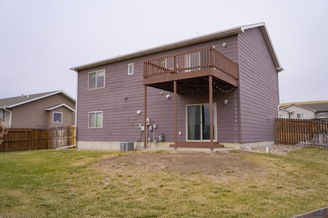 rear view of house featuring central AC unit and a lawn