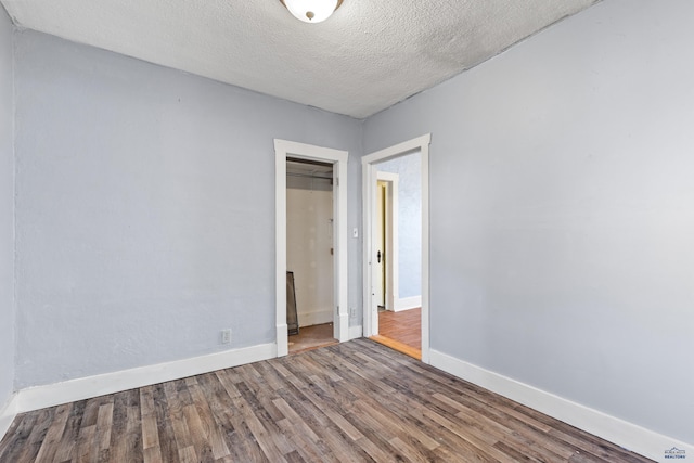 spare room featuring a textured ceiling and hardwood / wood-style floors