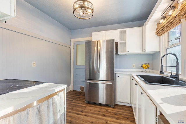 kitchen featuring sink, dark hardwood / wood-style floors, stainless steel refrigerator, and white cabinetry