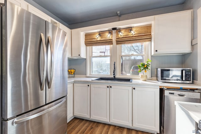 kitchen featuring light wood-type flooring, stainless steel appliances, white cabinetry, and sink