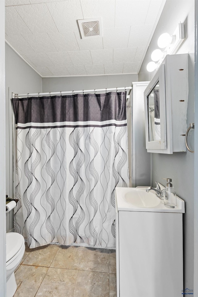 bathroom with toilet, vanity, tile patterned floors, and curtained shower