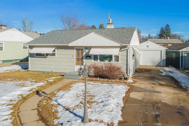 view of front of house with a garage and an outbuilding