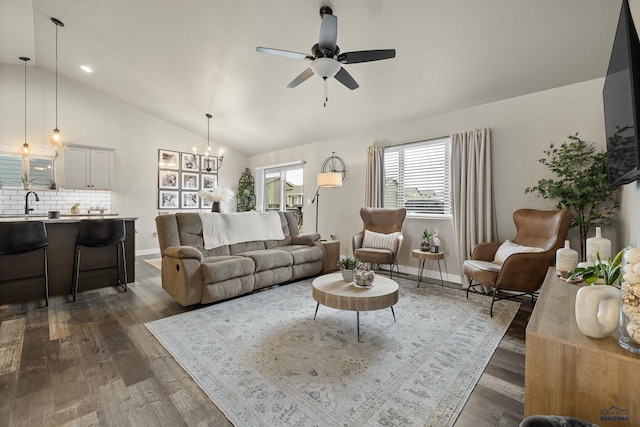 living room with vaulted ceiling, dark hardwood / wood-style floors, sink, and ceiling fan with notable chandelier