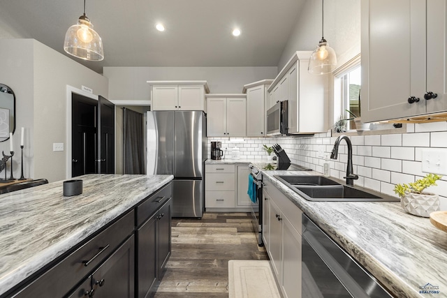 kitchen with tasteful backsplash, sink, hanging light fixtures, appliances with stainless steel finishes, and white cabinets