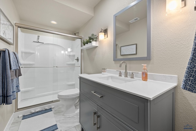 bathroom with a shower with shower door, toilet, and vanity