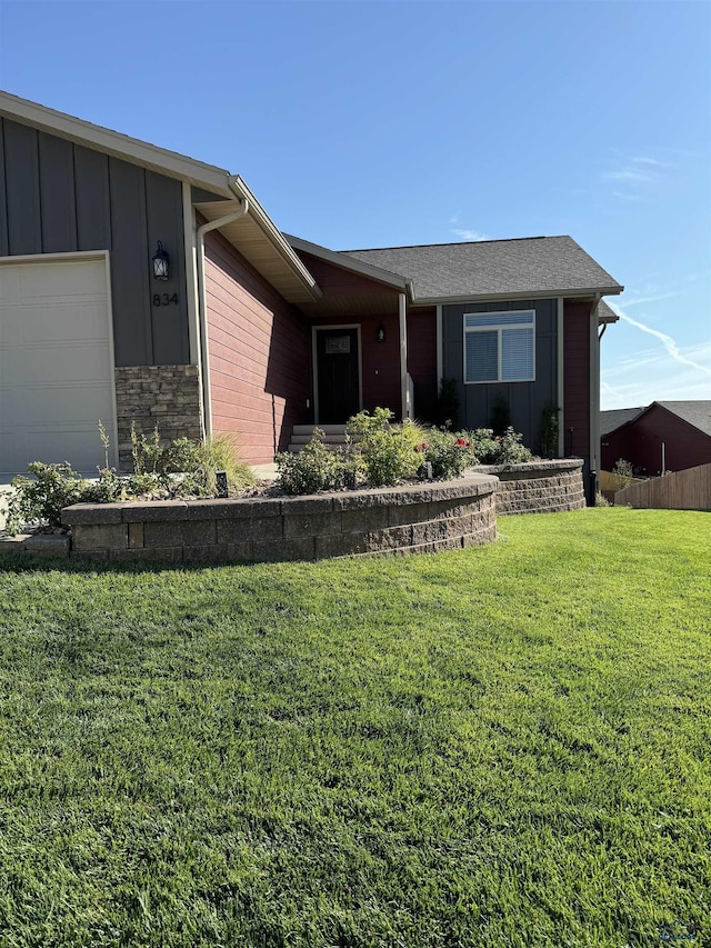 ranch-style home featuring a front lawn and a garage