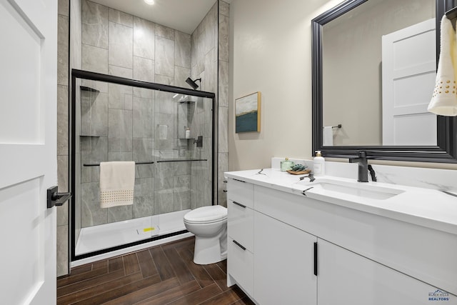 bathroom featuring walk in shower, parquet flooring, vanity, and toilet