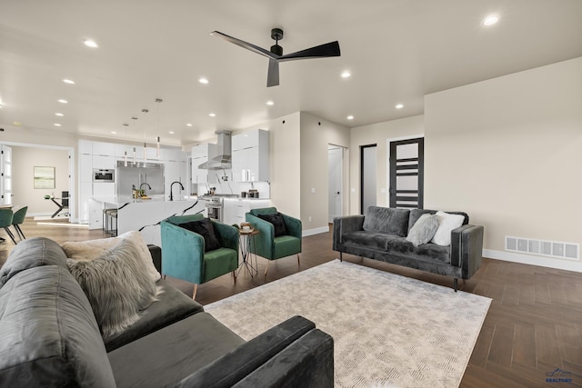 living room featuring ceiling fan and dark parquet flooring