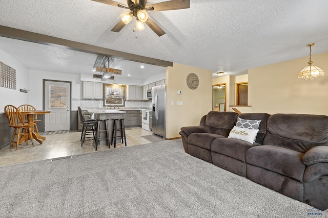 living room featuring ceiling fan, light colored carpet, and a textured ceiling