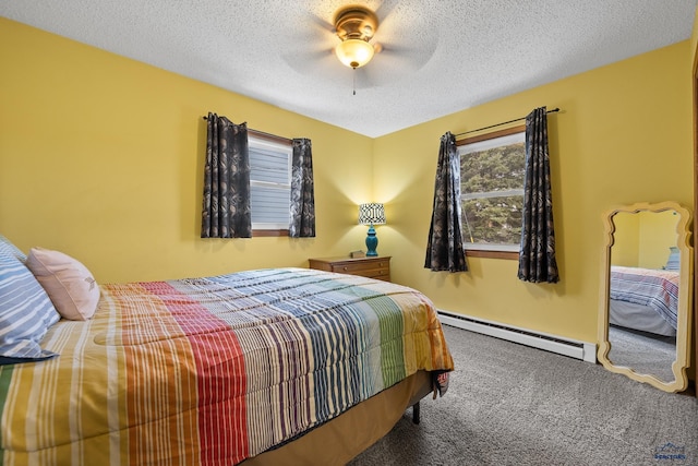 bedroom with ceiling fan, a baseboard heating unit, carpet floors, and a textured ceiling