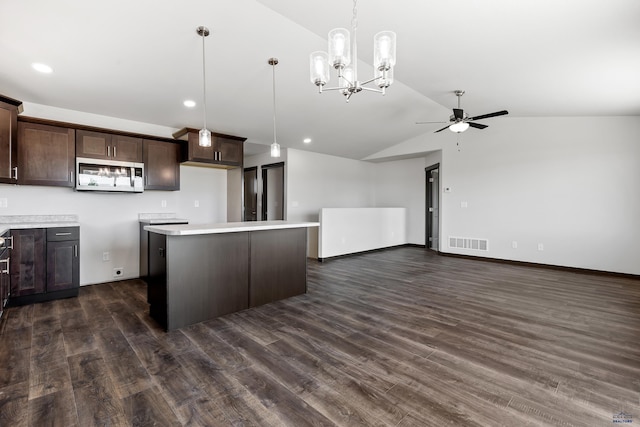 kitchen with dark brown cabinets, vaulted ceiling, a kitchen island, pendant lighting, and ceiling fan with notable chandelier