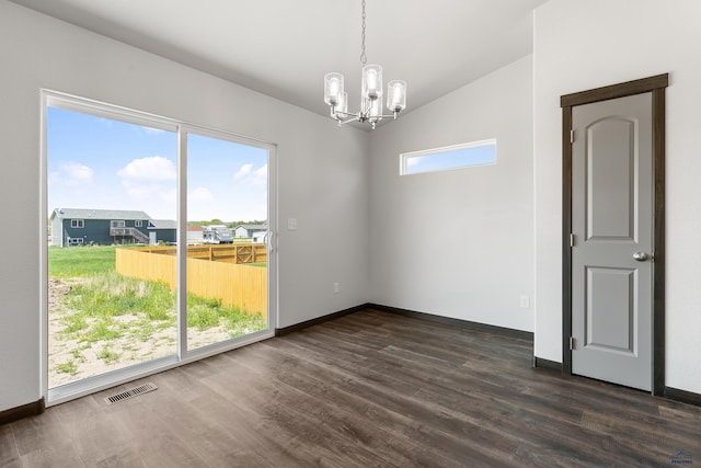 unfurnished room with dark wood-type flooring, an inviting chandelier, and lofted ceiling