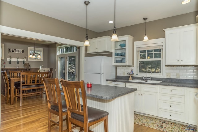 kitchen featuring decorative backsplash, white cabinets, and white appliances