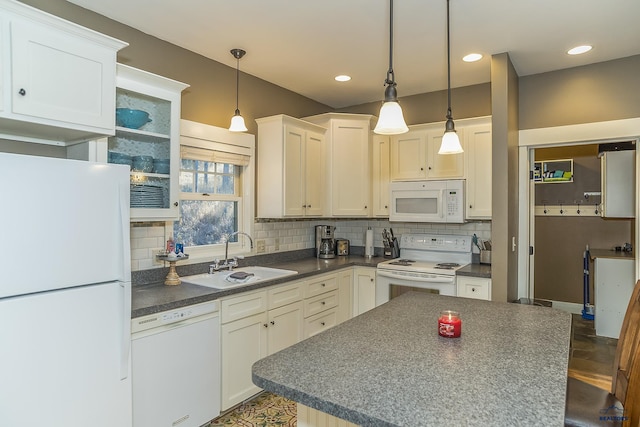 kitchen featuring white cabinetry, decorative backsplash, decorative light fixtures, white appliances, and sink