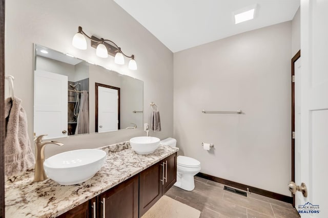 bathroom with toilet, vanity, and a shower with shower curtain