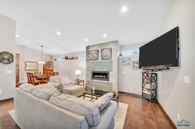 living room with lofted ceiling, a fireplace, and hardwood / wood-style floors