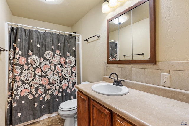 bathroom featuring vanity, decorative backsplash, and toilet