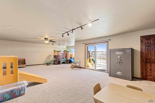 rec room featuring carpet floors, rail lighting, and a textured ceiling