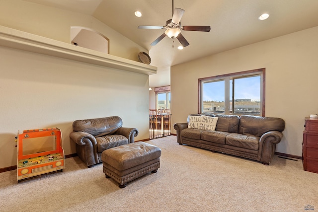 living room featuring ceiling fan, vaulted ceiling, and light carpet