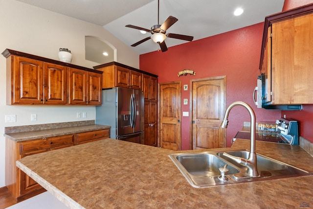 kitchen with vaulted ceiling, sink, ceiling fan, kitchen peninsula, and stainless steel appliances