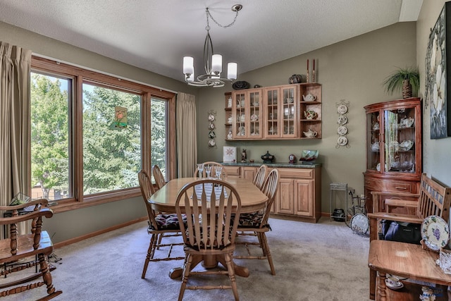 dining room featuring a textured ceiling, a chandelier, lofted ceiling, and light colored carpet