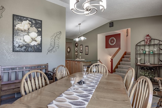 dining area featuring a textured ceiling, light hardwood / wood-style flooring, and lofted ceiling