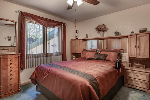 carpeted bedroom with ceiling fan and a textured ceiling