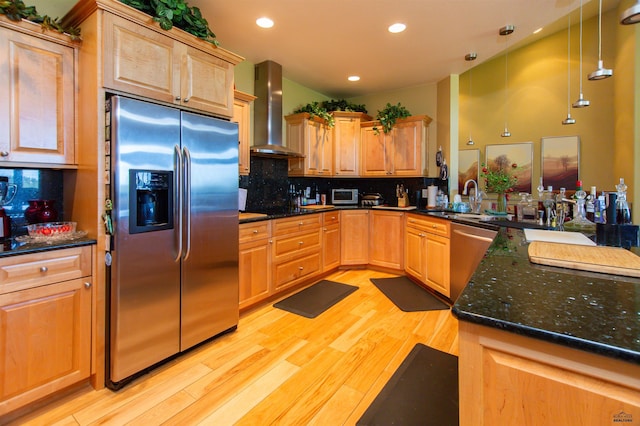 kitchen with appliances with stainless steel finishes, tasteful backsplash, sink, pendant lighting, and wall chimney exhaust hood