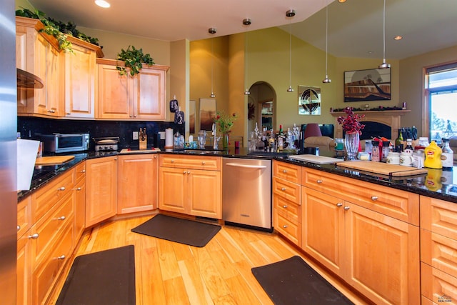 kitchen with dishwasher, decorative light fixtures, dark stone counters, backsplash, and light hardwood / wood-style flooring