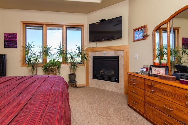 bedroom with a fireplace, multiple windows, and light carpet