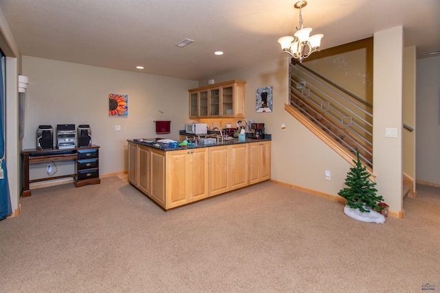 kitchen featuring light colored carpet, pendant lighting, light brown cabinets, and a chandelier