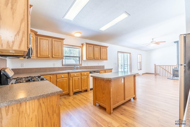 kitchen with a kitchen island, sink, stainless steel dishwasher, light hardwood / wood-style flooring, and stove