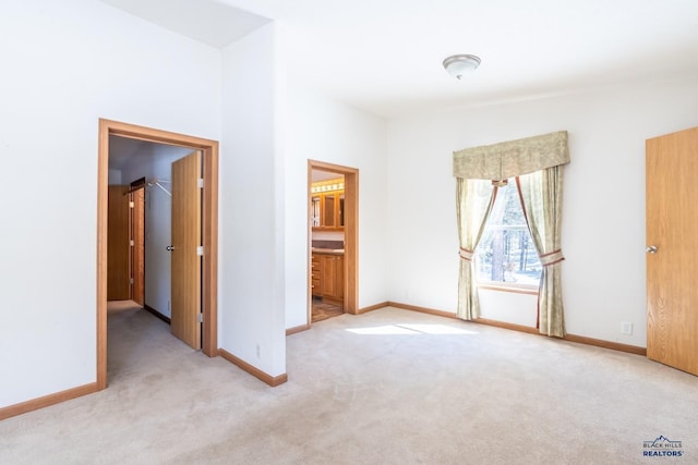 unfurnished bedroom featuring connected bathroom and light colored carpet