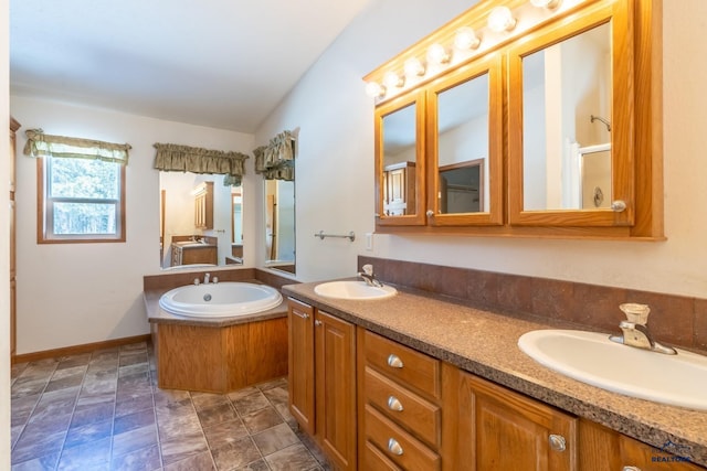 bathroom featuring vanity, vaulted ceiling, and a tub