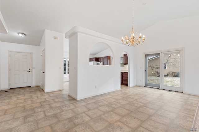 empty room with a chandelier and vaulted ceiling