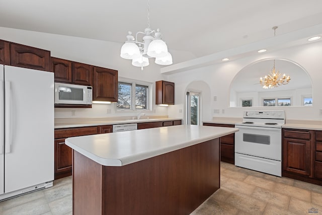 kitchen with pendant lighting, white appliances, a notable chandelier, and a kitchen island