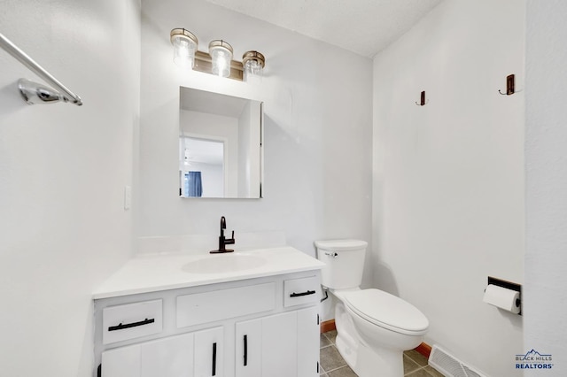 bathroom featuring vanity, toilet, and tile patterned flooring