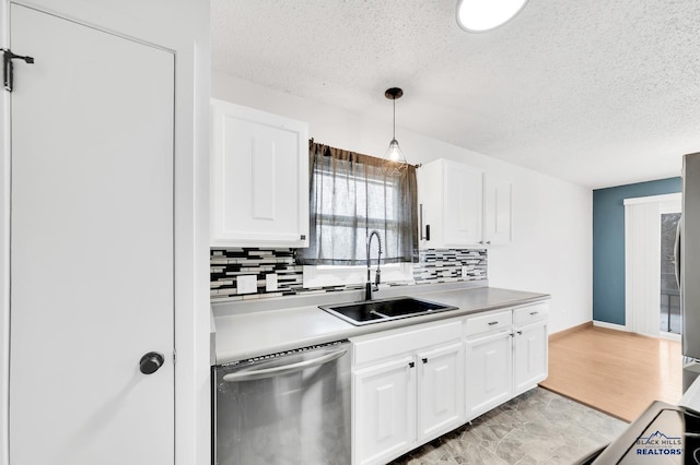 kitchen with sink, hanging light fixtures, white cabinets, and dishwasher