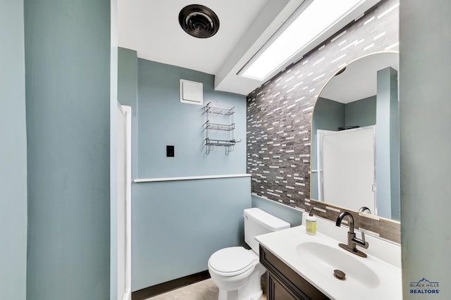 bathroom with vanity, toilet, and decorative backsplash