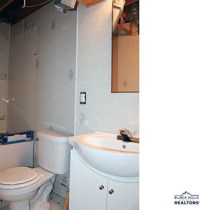 bathroom featuring decorative backsplash, tile walls, toilet, and vanity