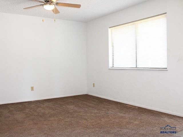 carpeted spare room with ceiling fan and a textured ceiling