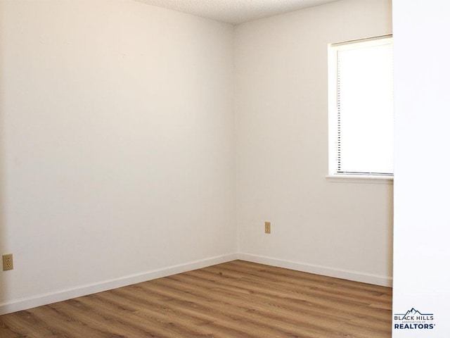 unfurnished room with wood-type flooring and a textured ceiling