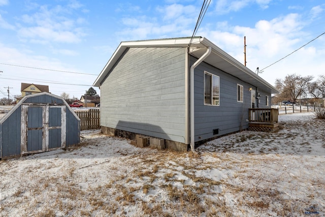 snow covered property featuring a storage unit