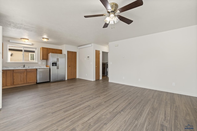 unfurnished living room featuring sink, hardwood / wood-style flooring, and ceiling fan